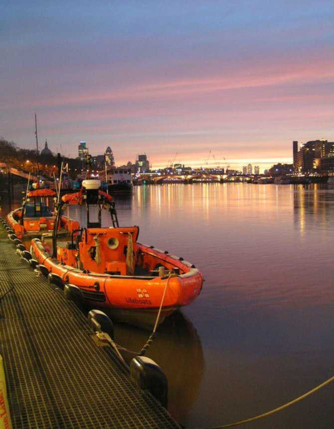 Crew enter water saving woman clinging to house barges in Battersea